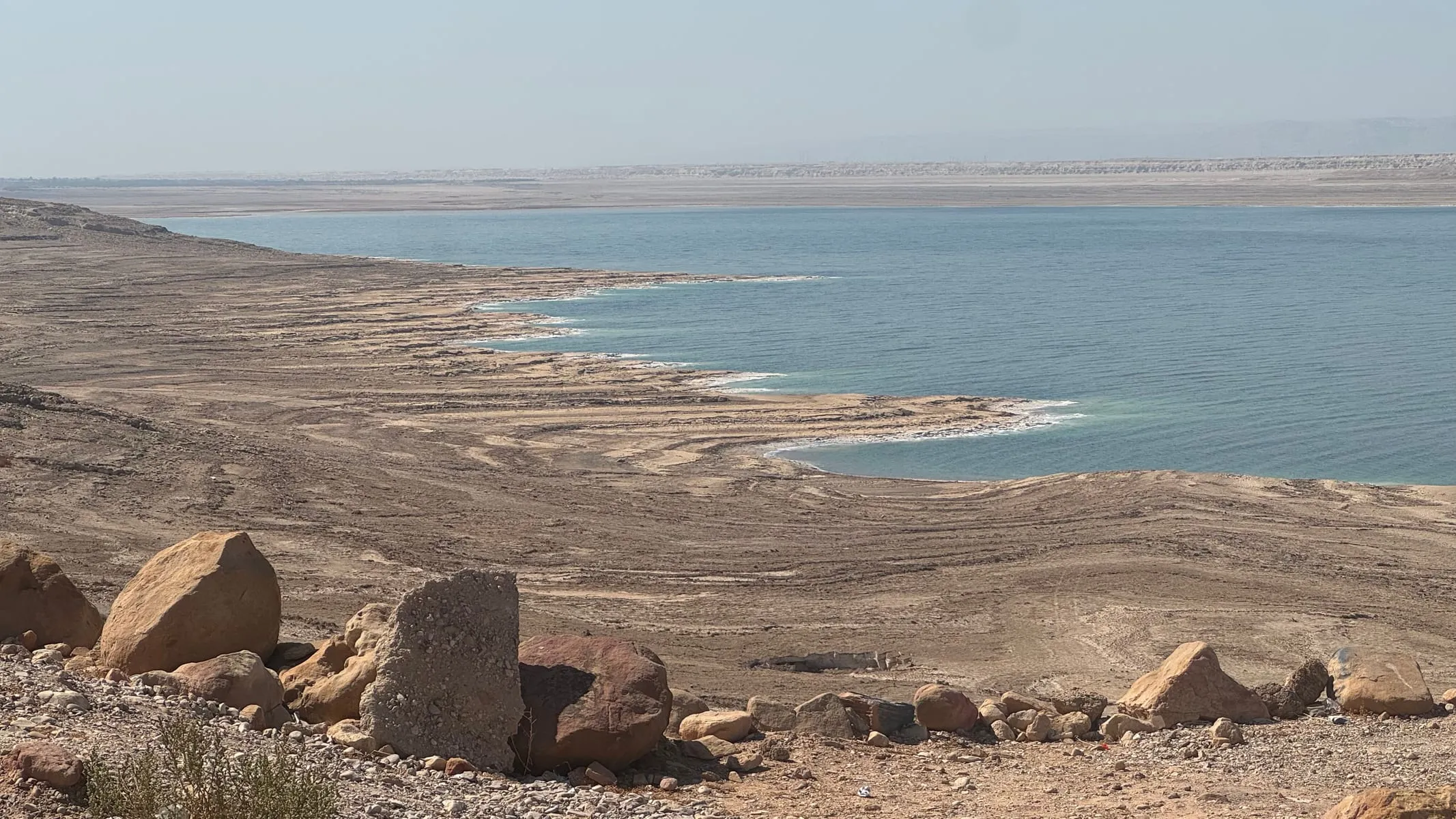 The Dead Sea's eastern shore, with pale salt flats and rocky desert in the foreground